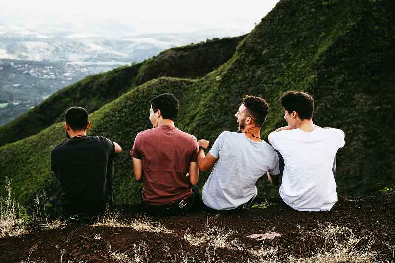 山の上で座る4人の男性
